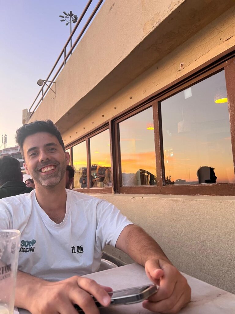João Matos, Coach de Desenho Humano, a sorrir numa esplanada ao pôr do sol